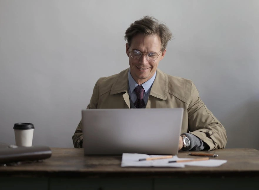 Uśmiechnięty profesjonalista analizujący dane na laptopie.